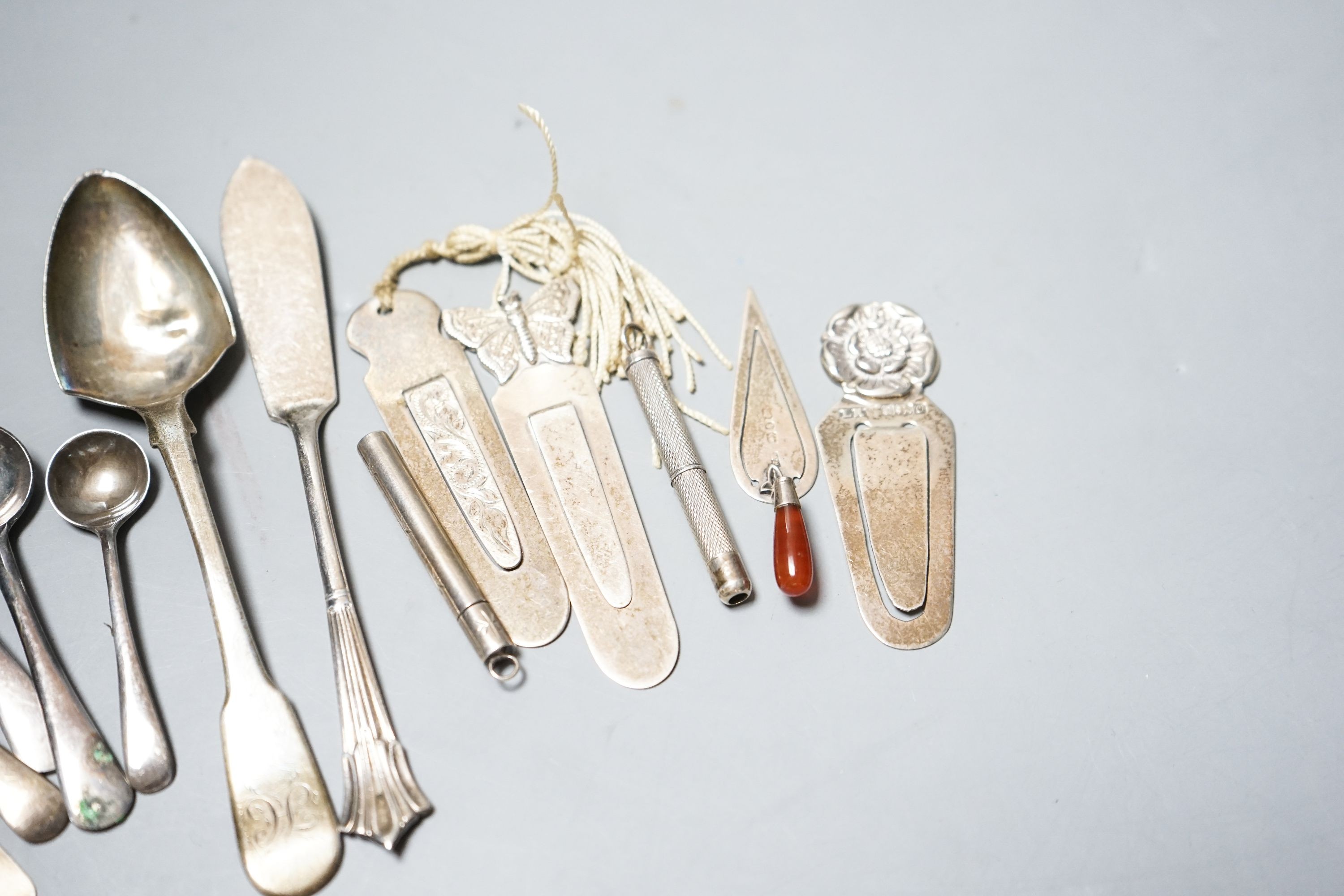 Five assorted silver bookmarks, a white metal cased toothpick, spoons etc.